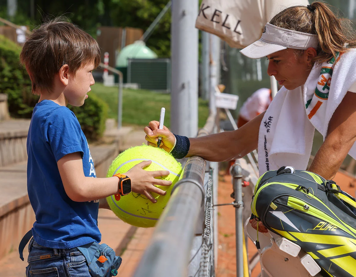 Tennisspielerin unterschreibt Riesenball für Kind